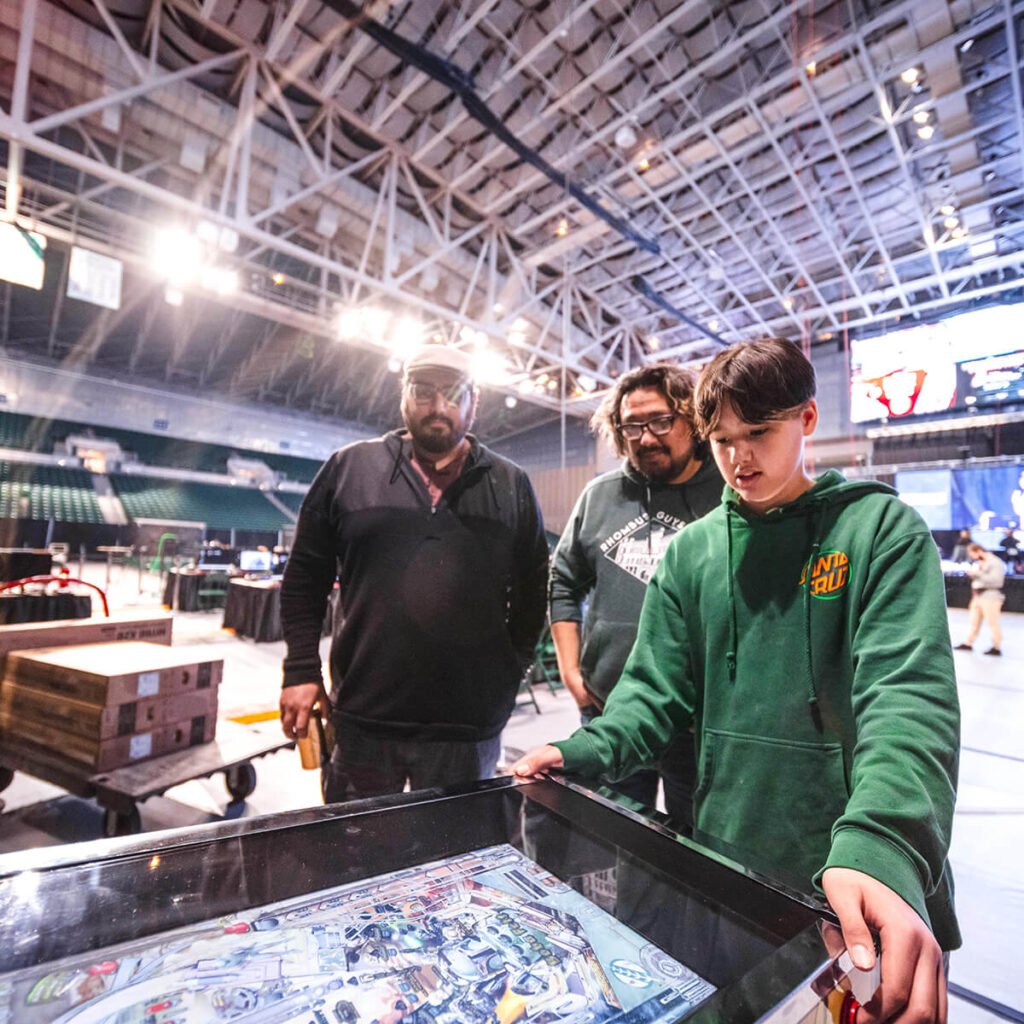 Boy showing his parents a pinball game